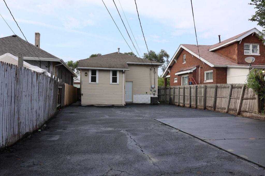 a street with two houses and a fence