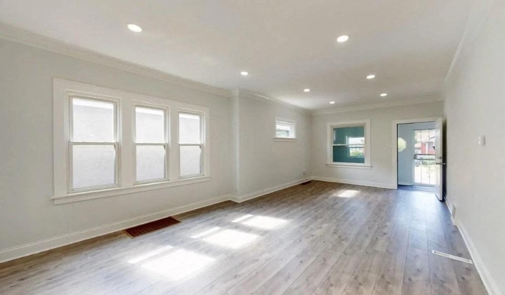 an empty living room with white walls and wood floors