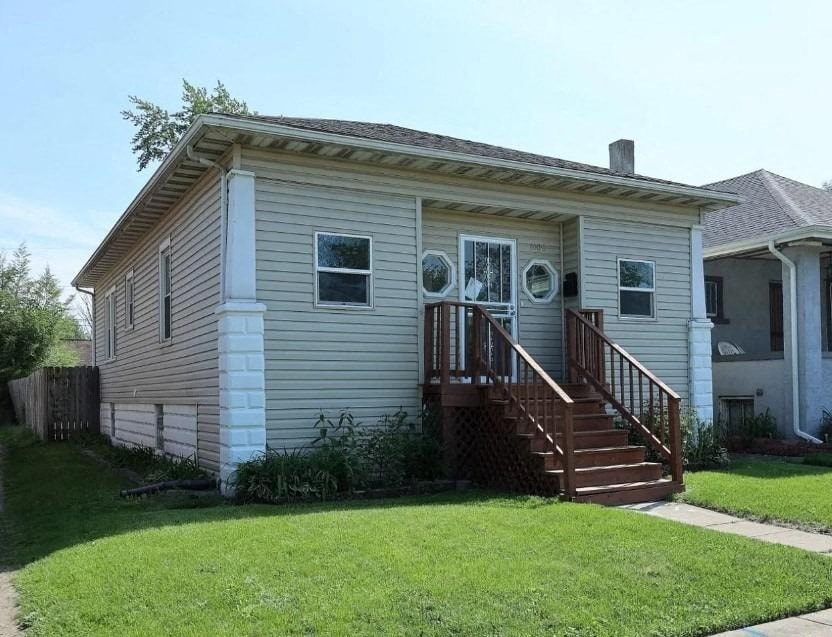 a small white house with a porch and a lawn