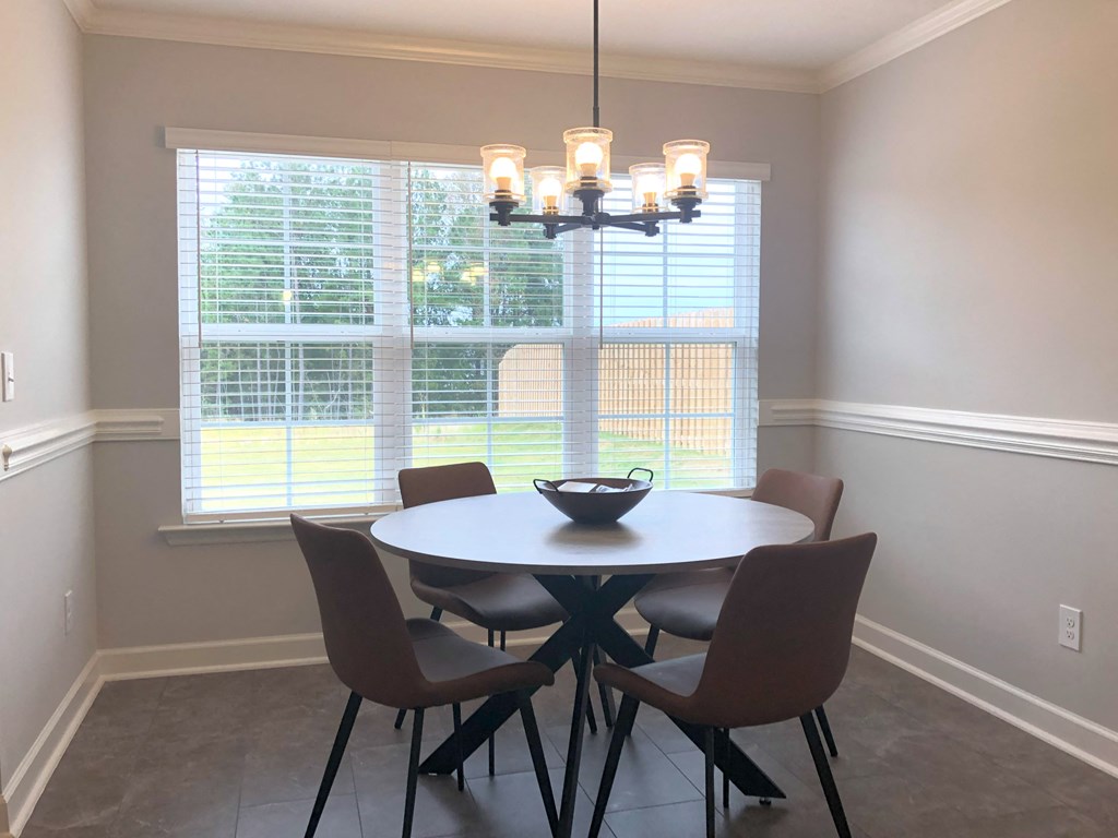 a dining room with a table and chairs and a large window