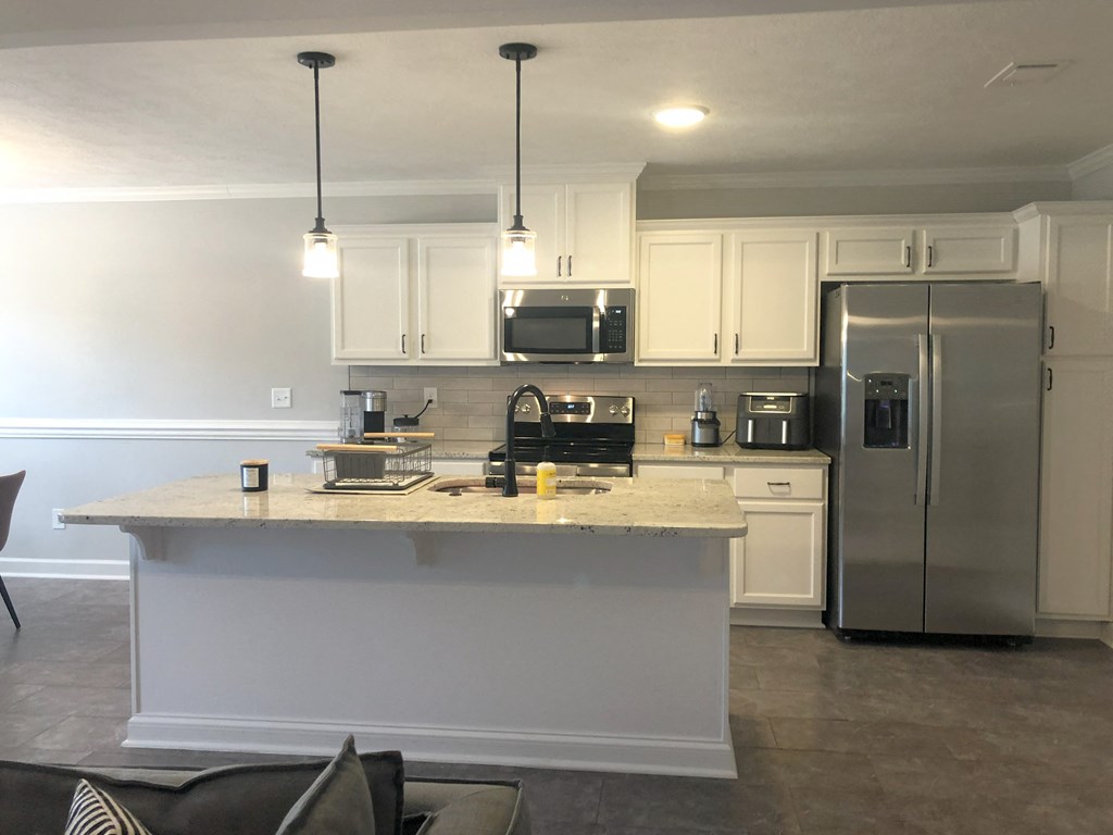 a kitchen with white cabinets and a counter top