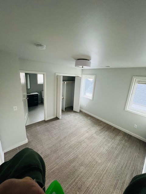 a living room with a couch and a carpet and a door to a bedroom