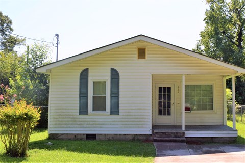 a small white house with windows and a porch