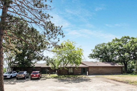 a house with a parking lot and cars in front of it