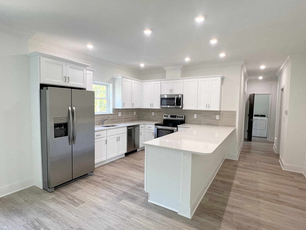 a kitchen with white cabinets and stainless steel appliances