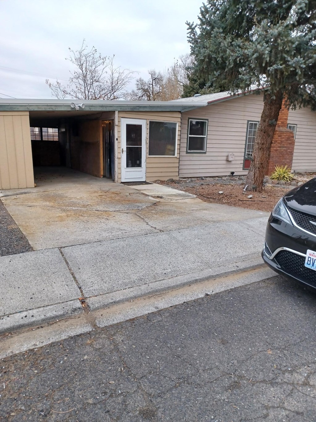 A car is parked in front of a garage.