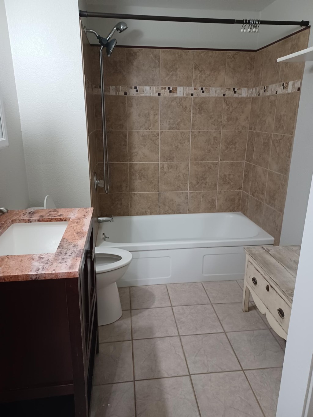 A bathroom with a tub, toilet, and sink.