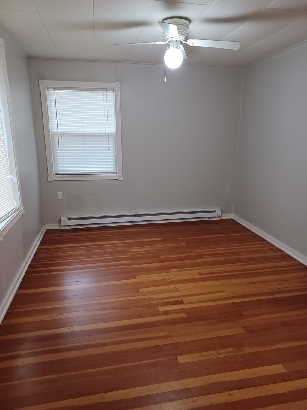 A room with wooden floors and a ceiling fan.
