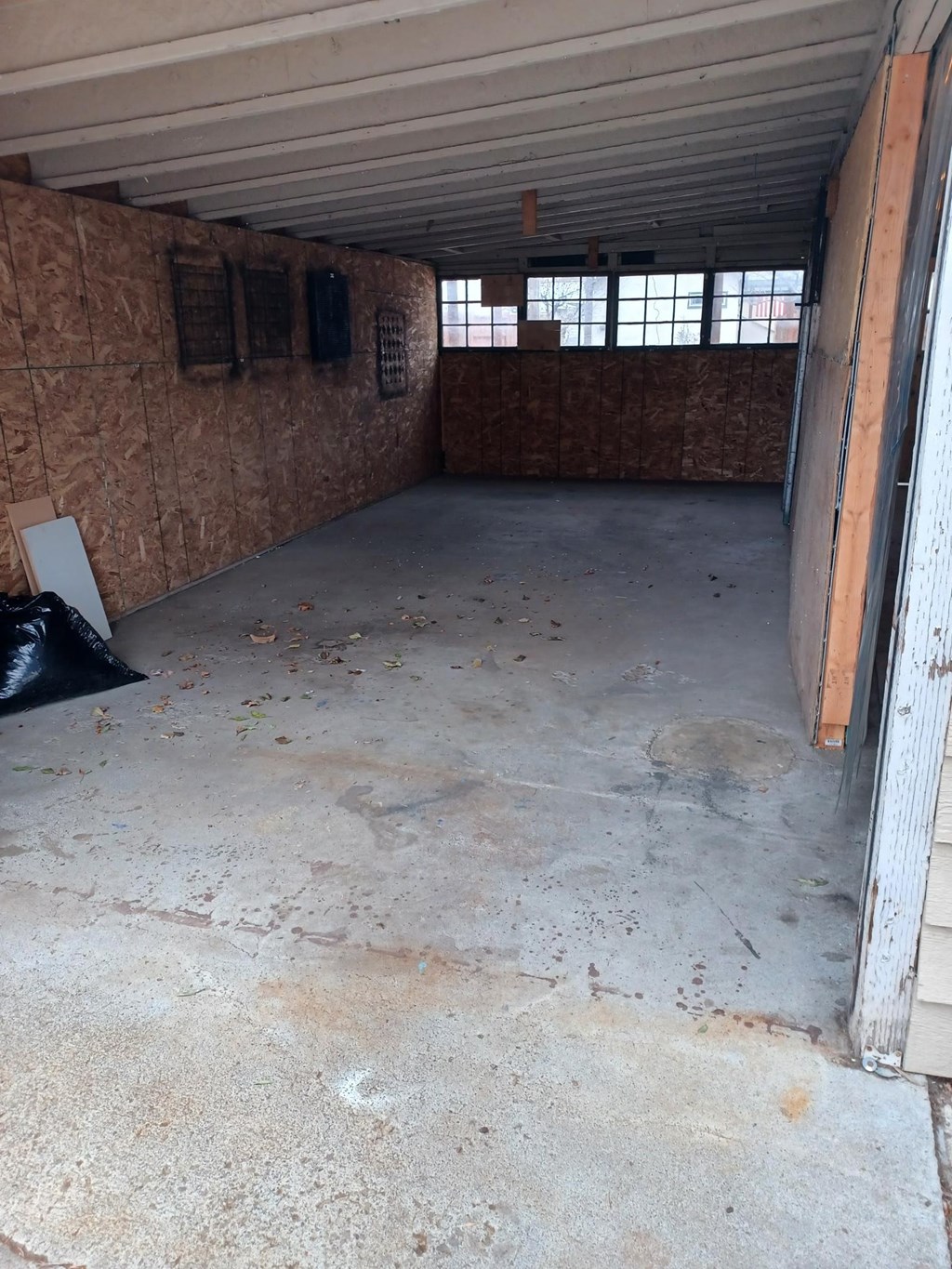 A room with a concrete floor and a brown wall.