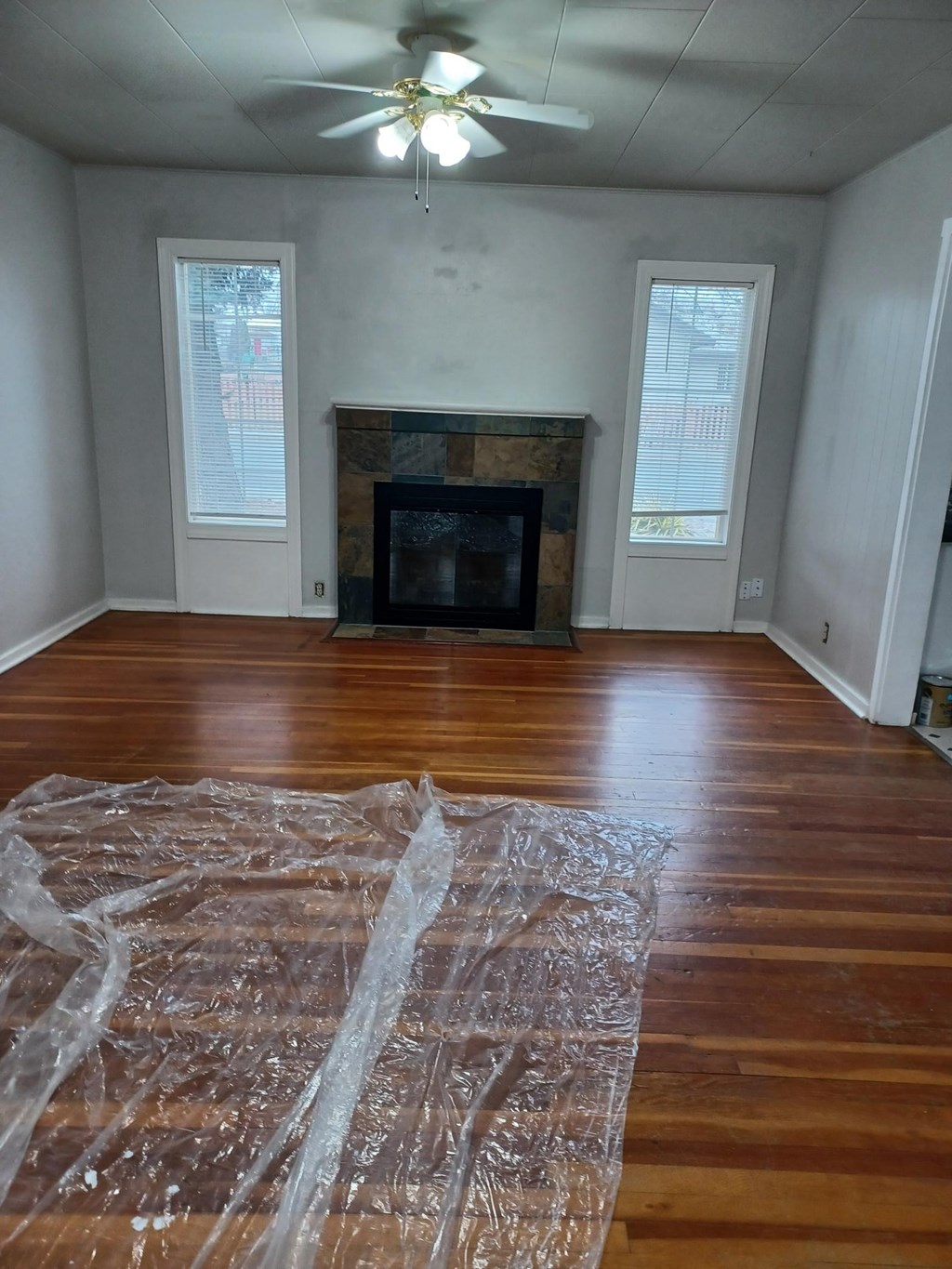 A room with a fireplace and a ceiling fan.