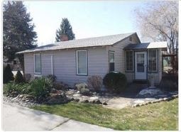 A small house with a grey roof and a white door.
