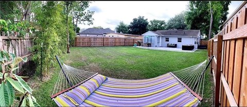 a hammock in the back yard of a house