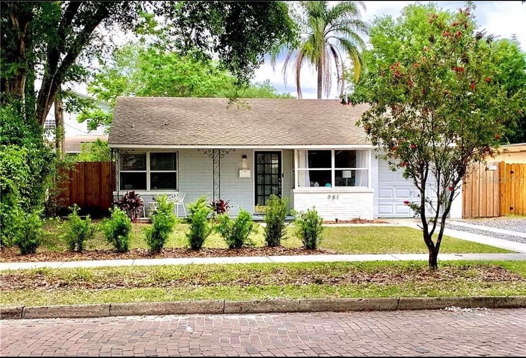 a small white house with a tree in the front yard
