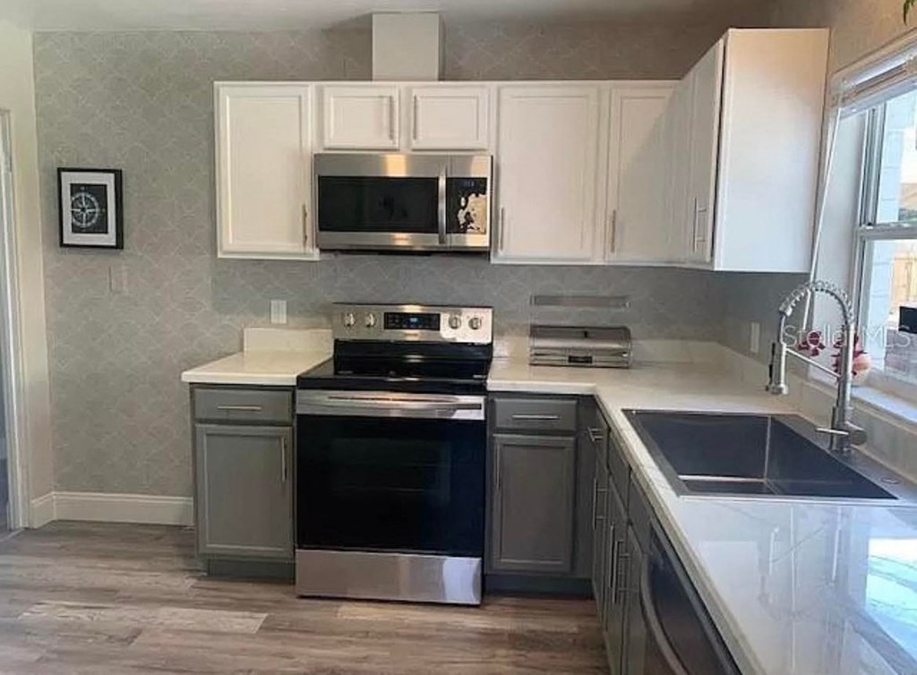 a kitchen with stainless steel appliances and white cabinets