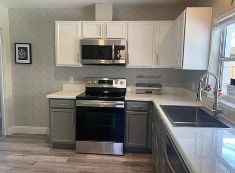 a kitchen with stainless steel appliances and white cabinets