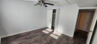 an empty room with a ceiling fan and a closet