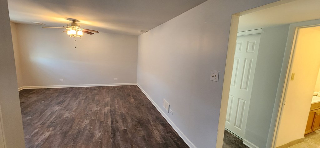 a living room with wood flooring and a ceiling fan