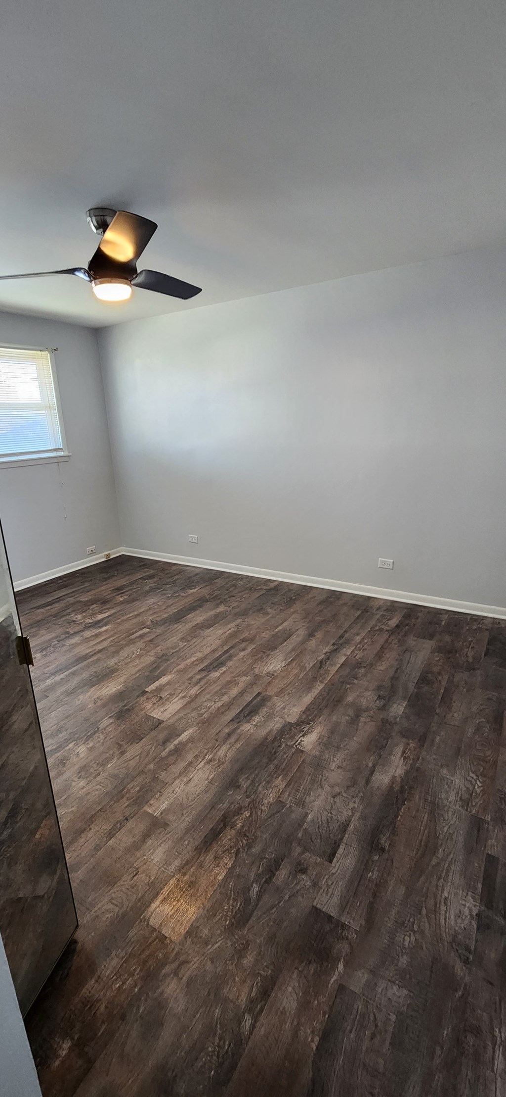 a living room with wood flooring and a ceiling fan