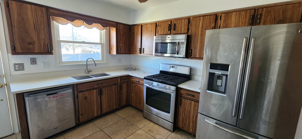 a kitchen with stainless steel appliances and wooden cabinets