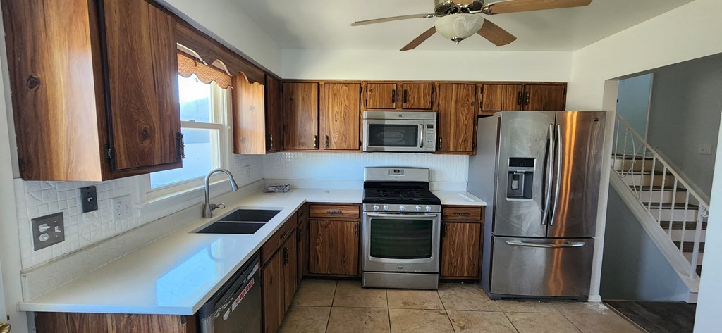 a kitchen with wooden cabinets and stainless steel appliances