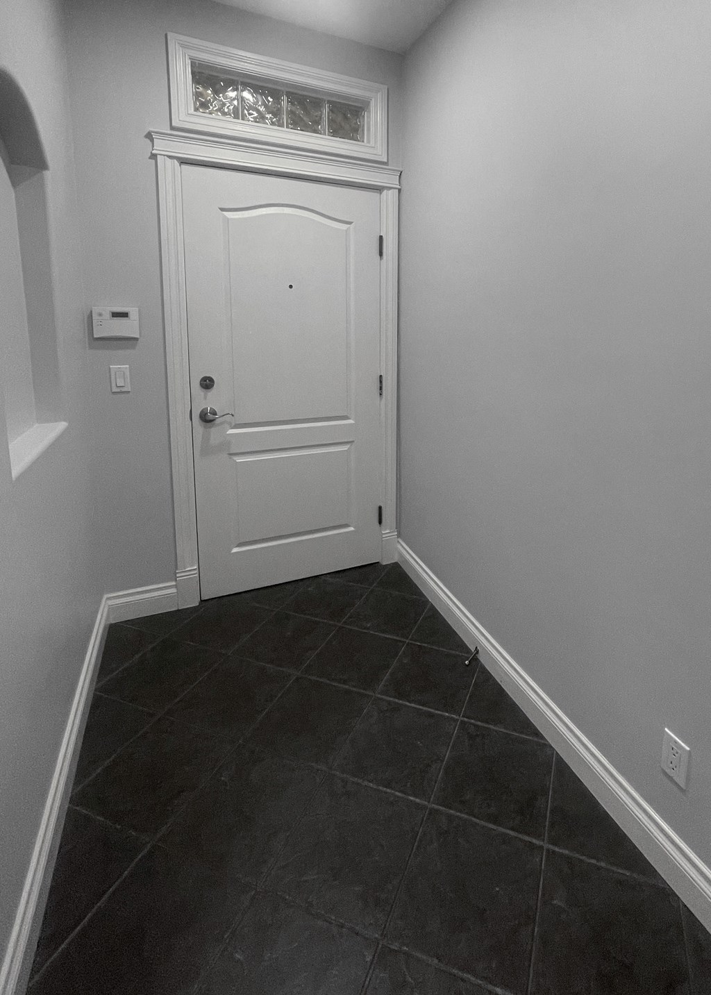 a black and white photo of a room with a white door