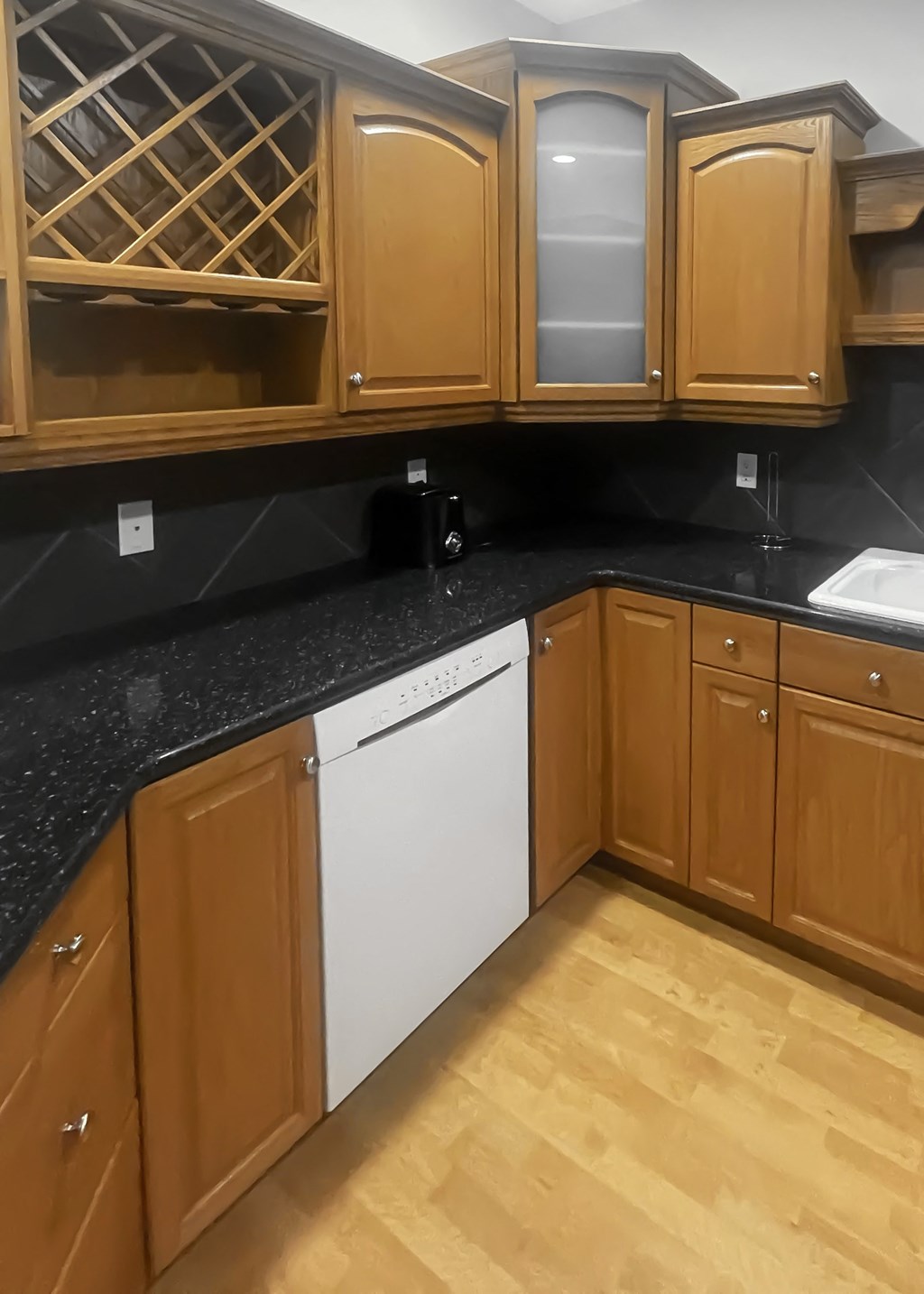 a kitchen with wooden cabinets and a white dishwasher