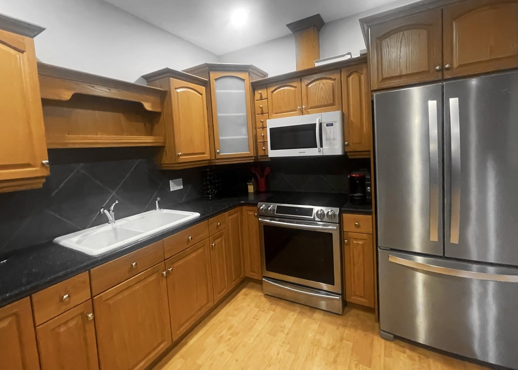 a kitchen with stainless steel appliances and wooden cabinets