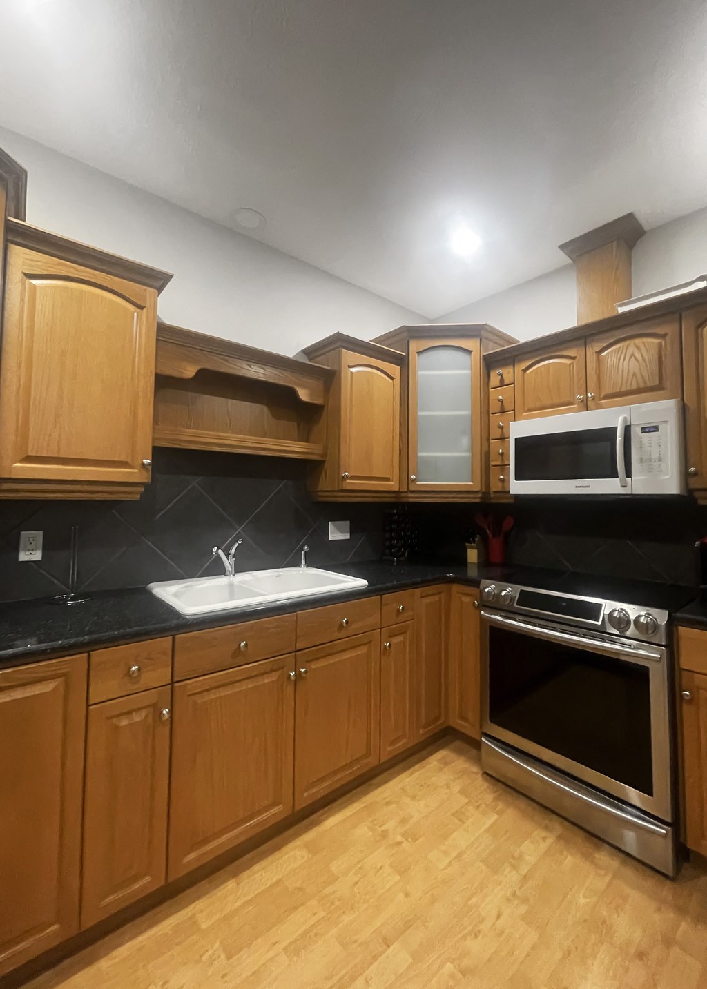 a kitchen with wooden cabinets and stainless steel appliances