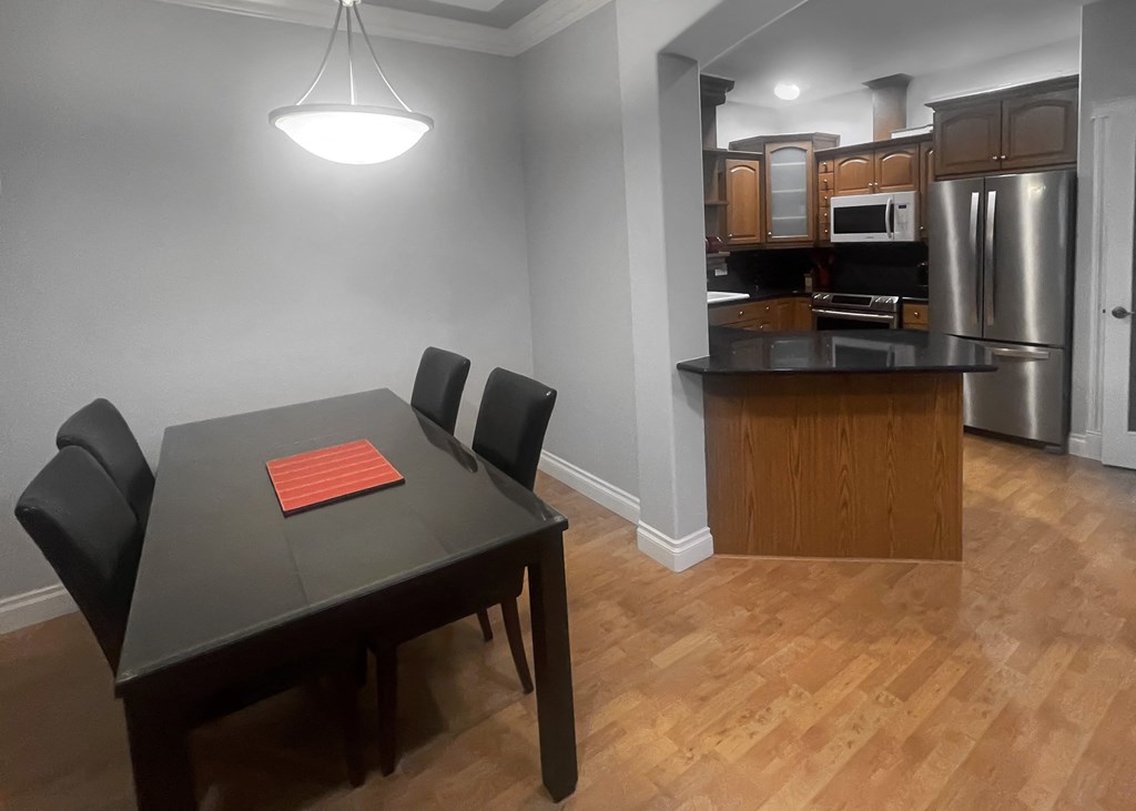 a kitchen and dining room with a black table and chairs