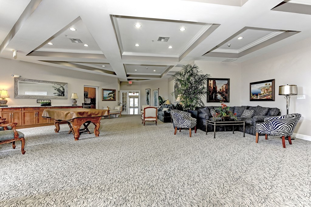 a large living room with a pool table and couches
