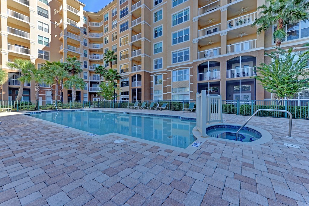 a swimming pool with an apartment building in the background