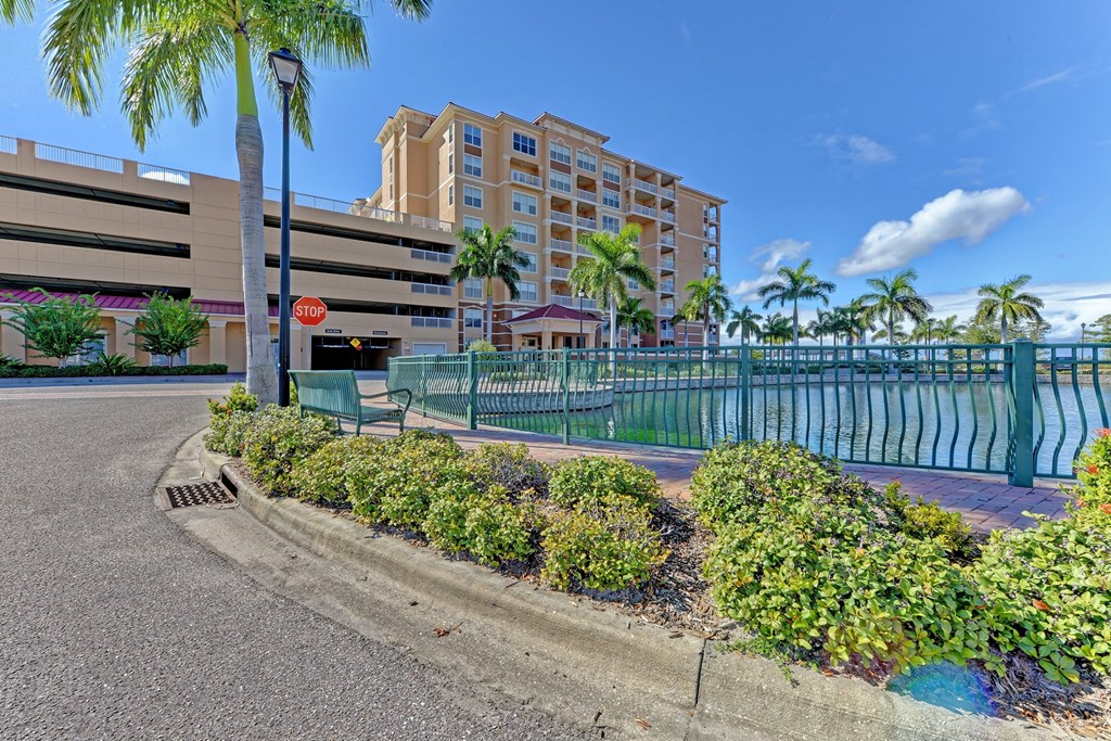 a street with a pool and a building with palm trees