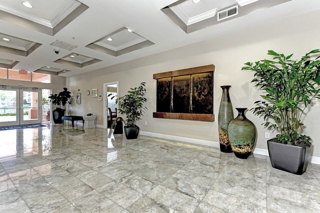 a lobby with large vases and a painting on the wall