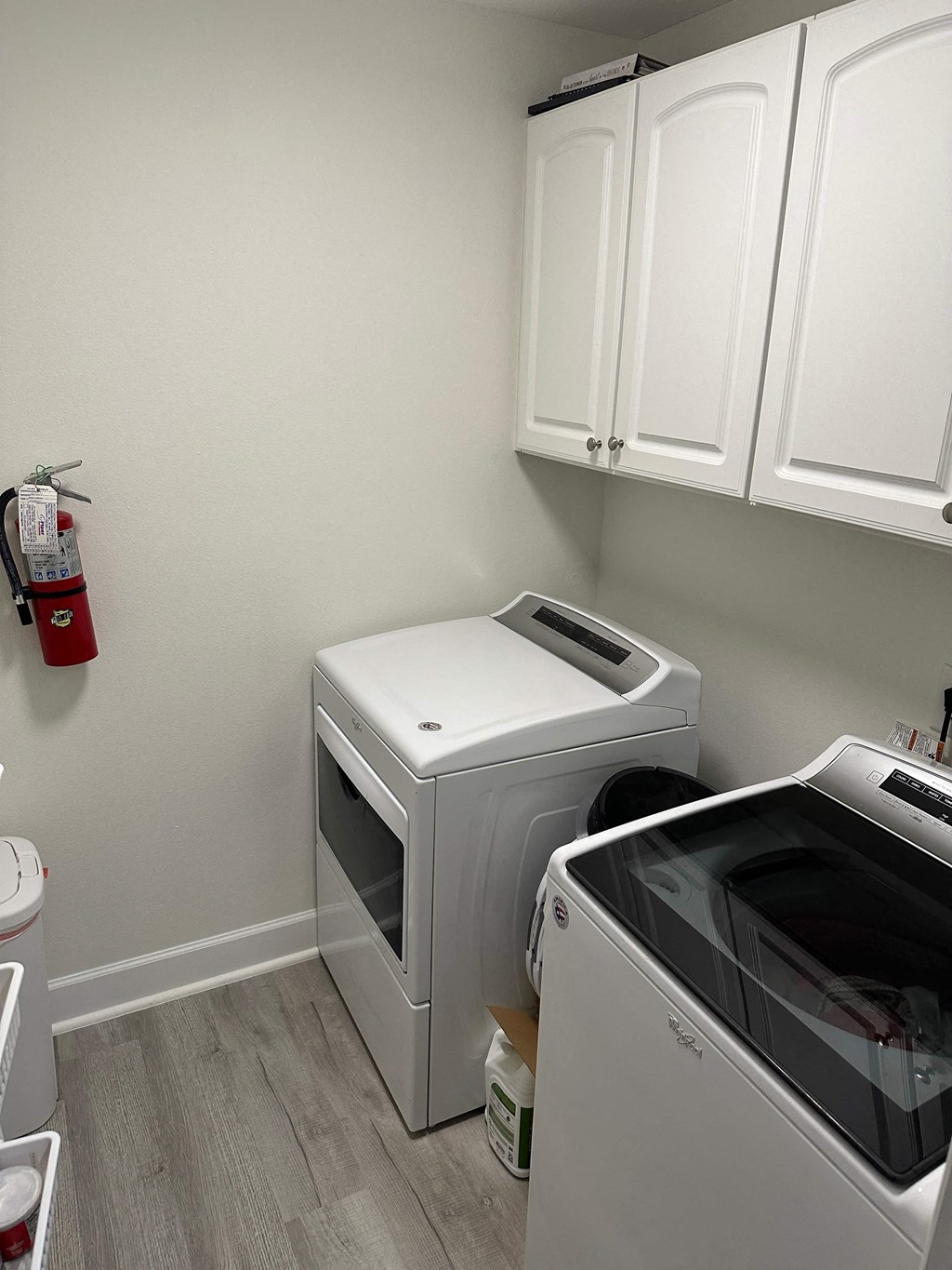 a washer and dryer in a laundry room with white cabinets