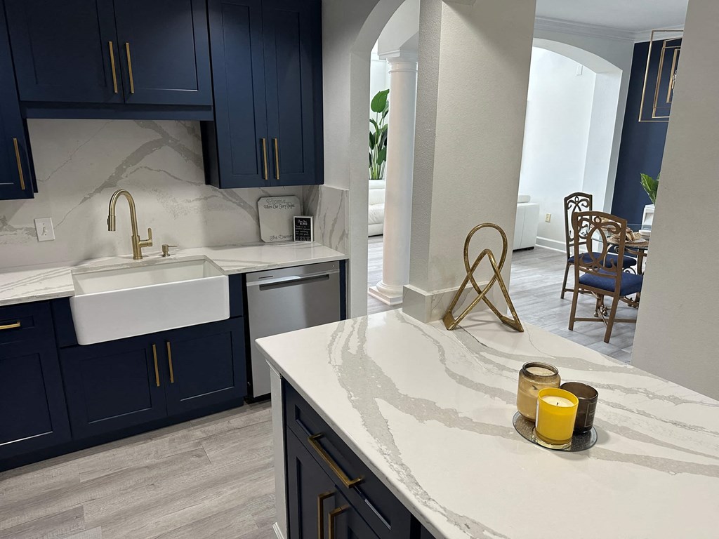 a kitchen with blue cabinets and a marble counter top