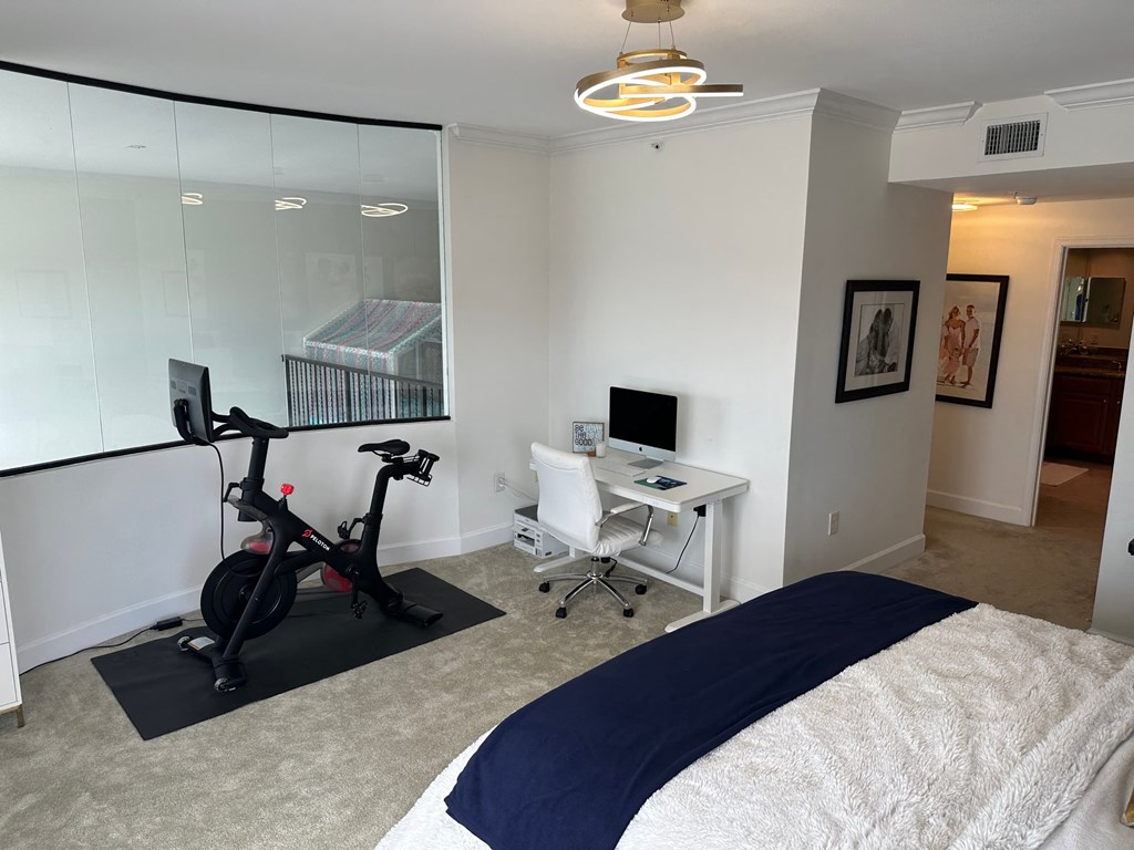 a bedroom with a bed and a desk with a bike in it