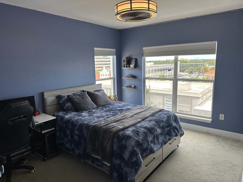 a bedroom with a bed and a large window