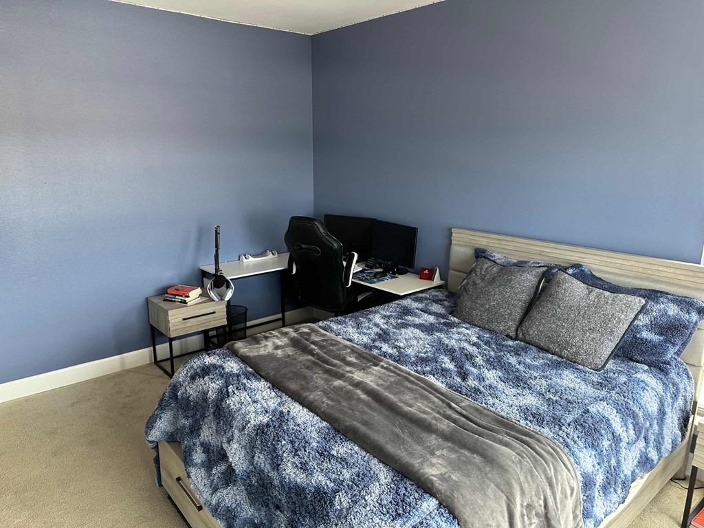 a bedroom with a bed and a blue wall