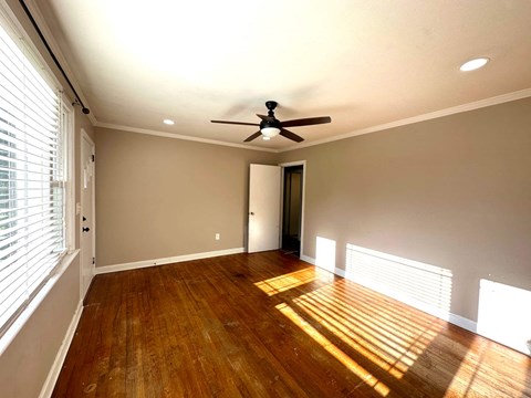a living room with wood floors and a ceiling fan
