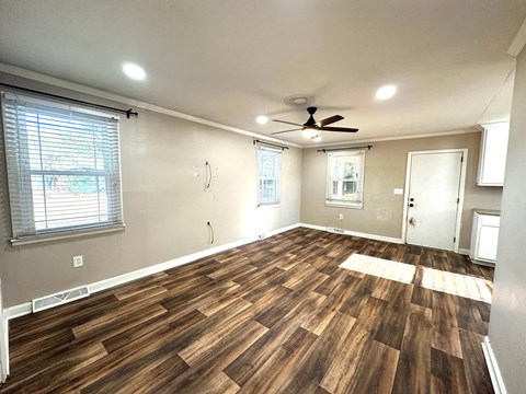 a living room with wood floors and a ceiling fan