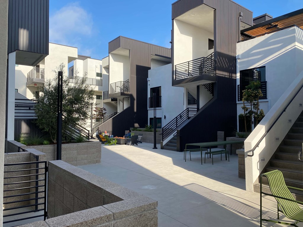 a row of modern apartments with stairs and a courtyard