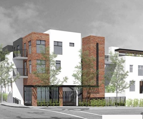 A modern two-story building with a black and white exterior and a brick chimney.