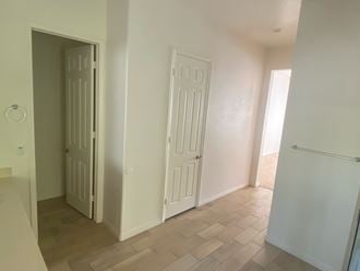 an empty room with two doors and a hallway