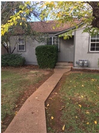 a house with a yard and a sidewalk in front of it