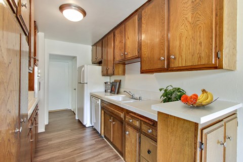 A kitchen with wooden cabinets and a white refrigerator.