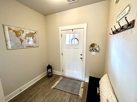 a entryway with a white door and a world map on the wall