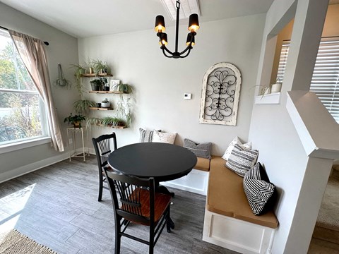 a dining room with a table and a couch and a chandelier