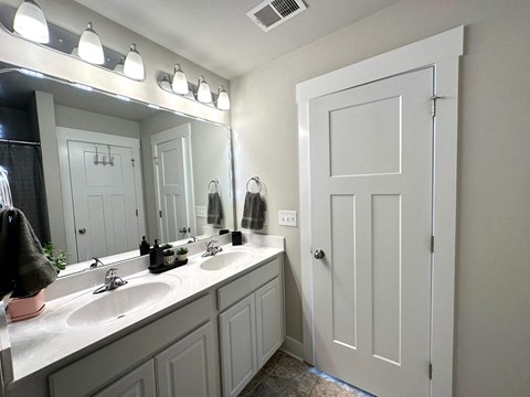 a bathroom with two sinks and a large mirror