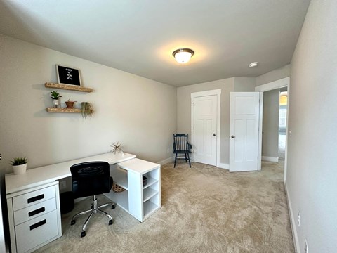 a home office with a white desk and a chair