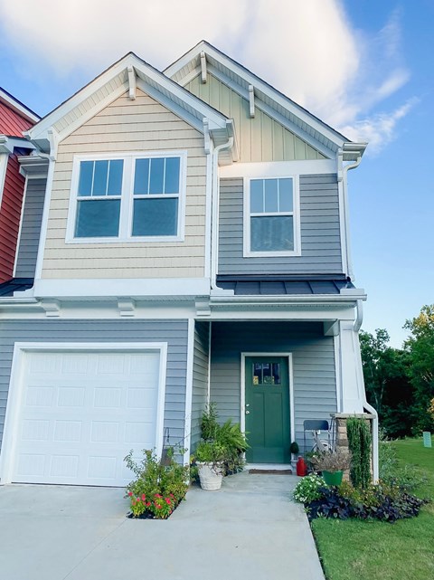 a house with a green door and a white garage door